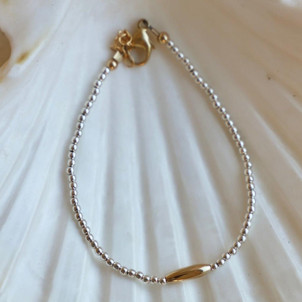 The Miniature Roman Bracelet features a unique combination of silver beaded links and a gold accent oval. Crafted with high quality materials, this chic bracelet is perfect for accessorizing an outfit and adding a touch of sparkle