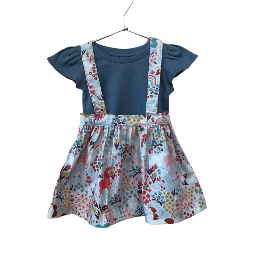 The Andi mini trouser skirt has adjustable suspenders with a button on the back. Two button holes are sewn on each suspender strap so your child can grow with their skirt making it easy to wear high on her waist when they are younger &amp; on their natural waist when older. Fabric designed by Ashley Collett for Riley Blake.