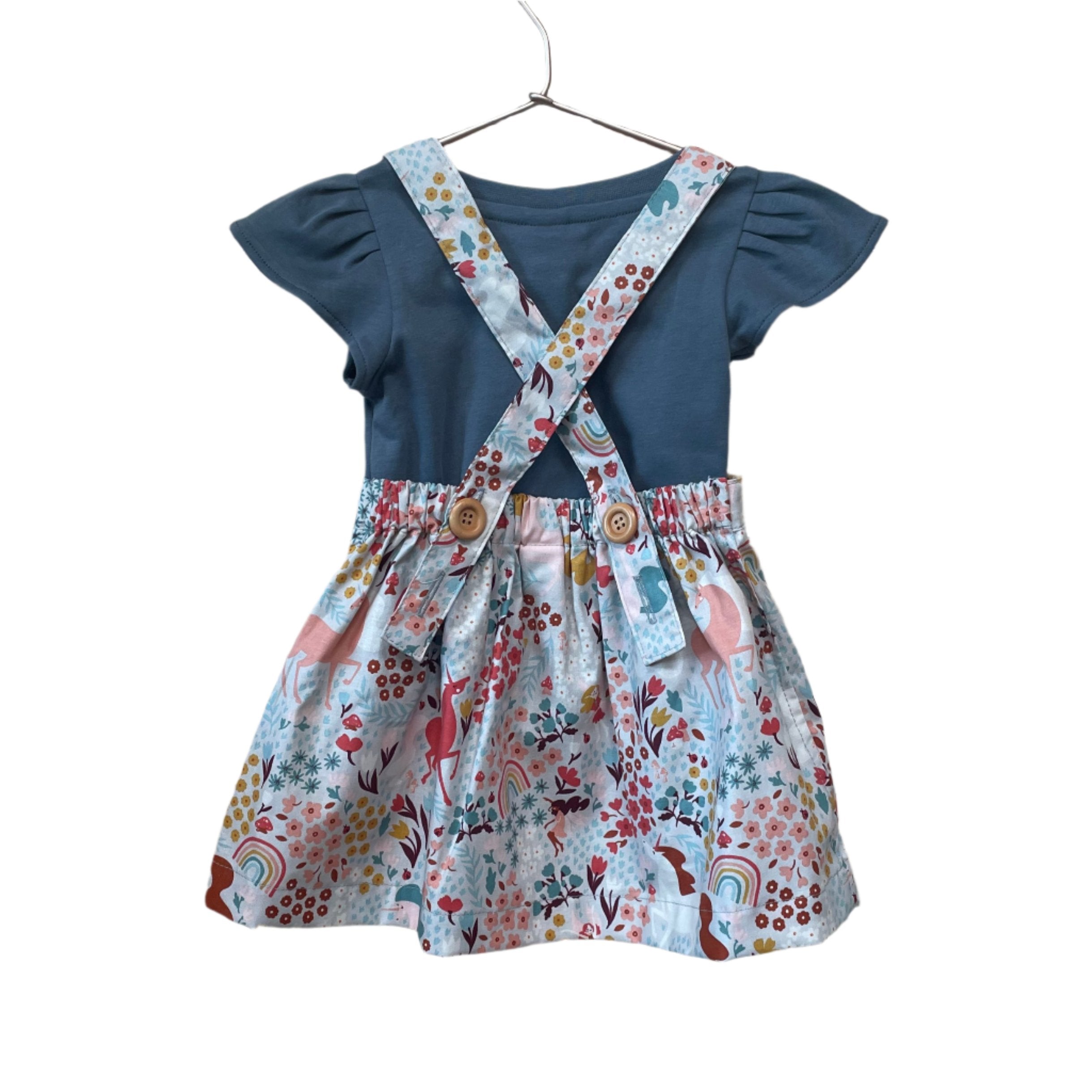 The Andi mini trouser skirt has adjustable suspenders with a button on the back. Two button holes are sewn on each suspender strap so your child can grow with their skirt making it easy to wear high on her waist when they are younger &amp; on their natural waist when older. Fabric designed by Ashley Collett for Riley Blake.
