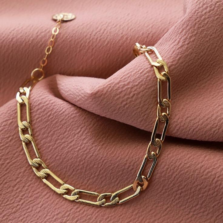 Channel your inner queen with our Cleopatra Chain Bracelet. Made with 24kt gold plating, this bracelet features a stunning coin drop and a classic cleopatra chain. Perfect for adding some regal flair to any outfit.
