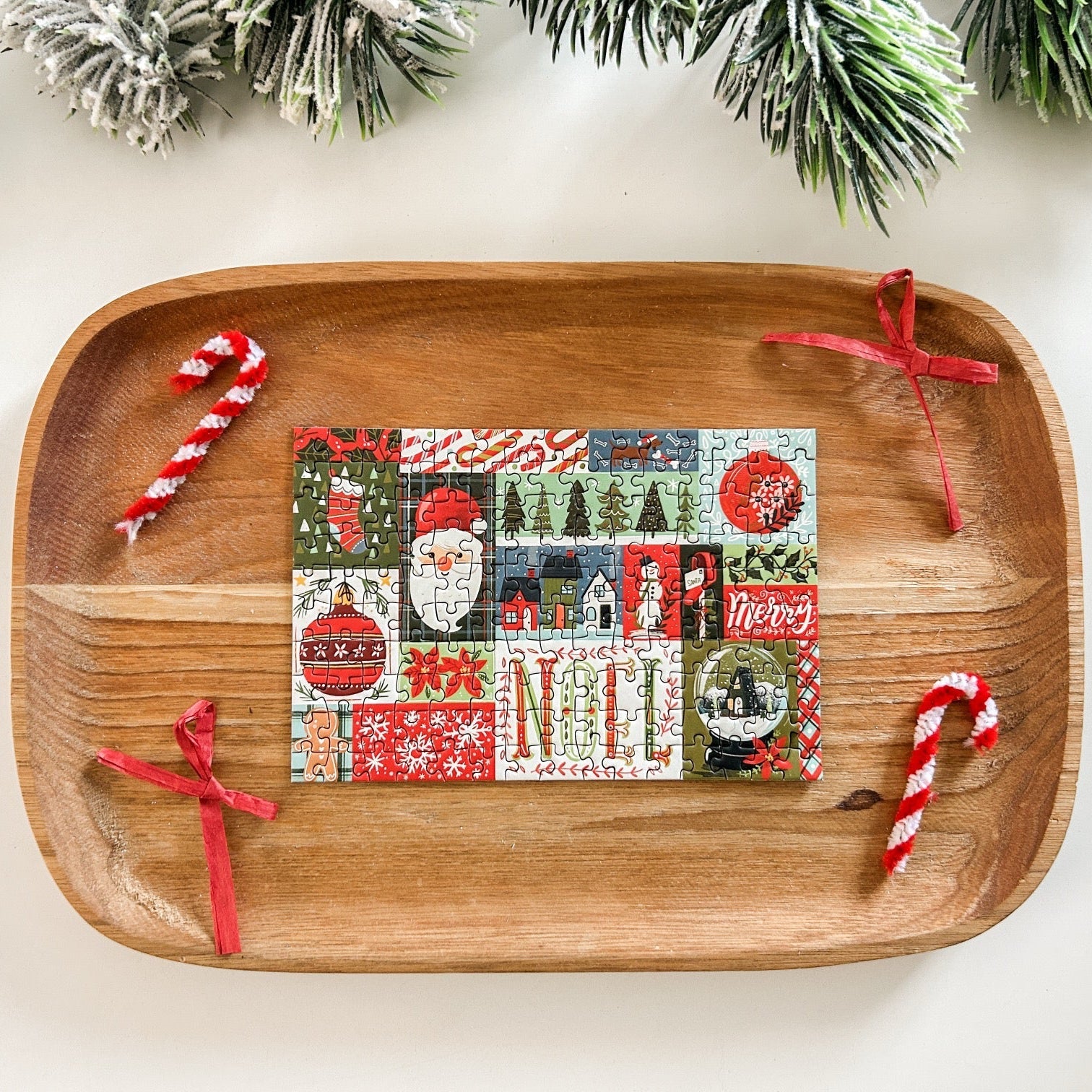 Completed puzzle on a wooden tray with bows and candy canes as decor.