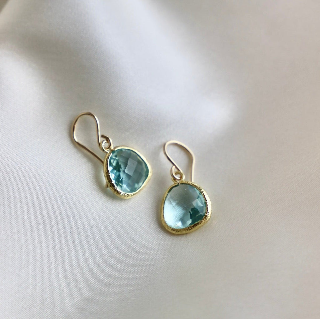 Our signature faceted glass bezel earrings in the color aquamarine