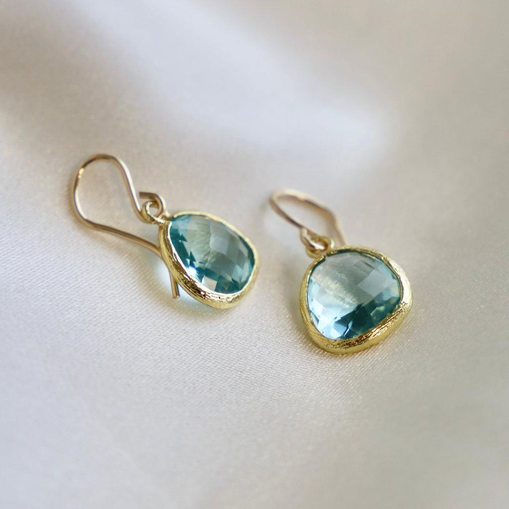 Our signature faceted glass bezel earrings in the color aquamarine