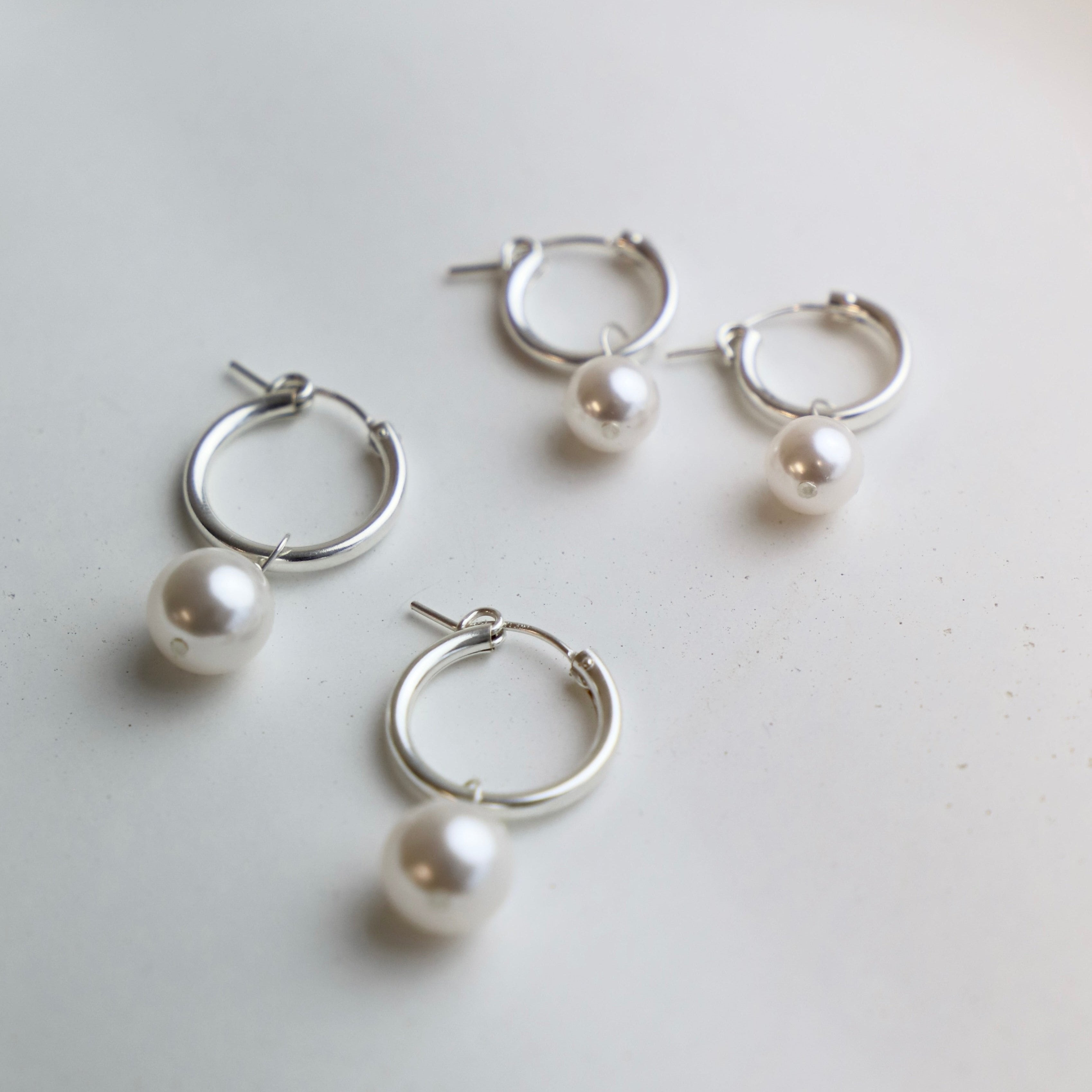 Get ready to add some pizzazz to your outfit with our Audrey Pearl Hoop Earrings in silver. These hoops feature stylish pearls, adding a touch of elegance to your look. Perfect for a night out or to dress up your everyday style. Small hoop is 2x13mm