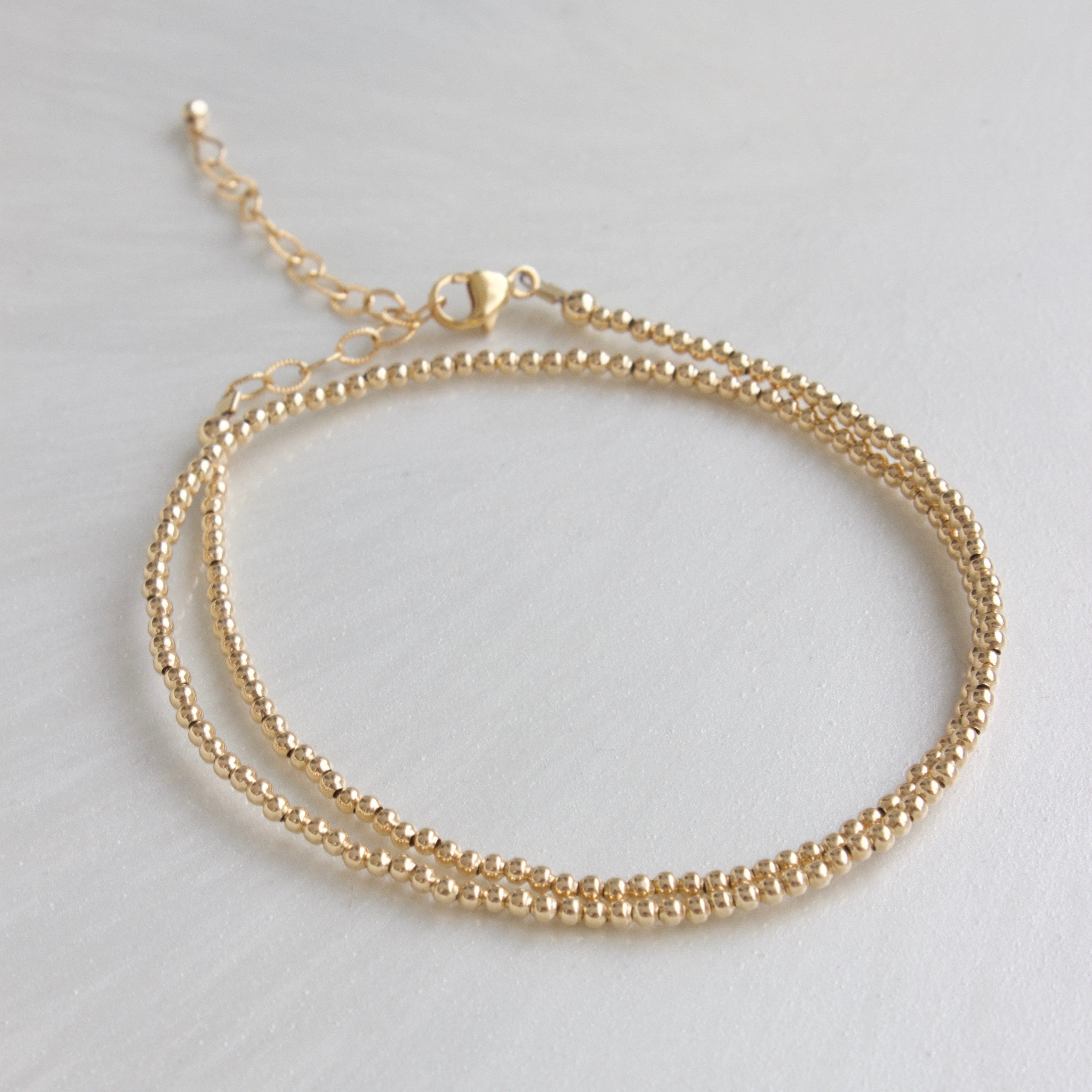 Our double wrap bracelet is one of our number one best selling bracelets! The petite double wrap beaded bracelet features a 2mm bead that can be worn as a bracelet or a single layer choker necklace!