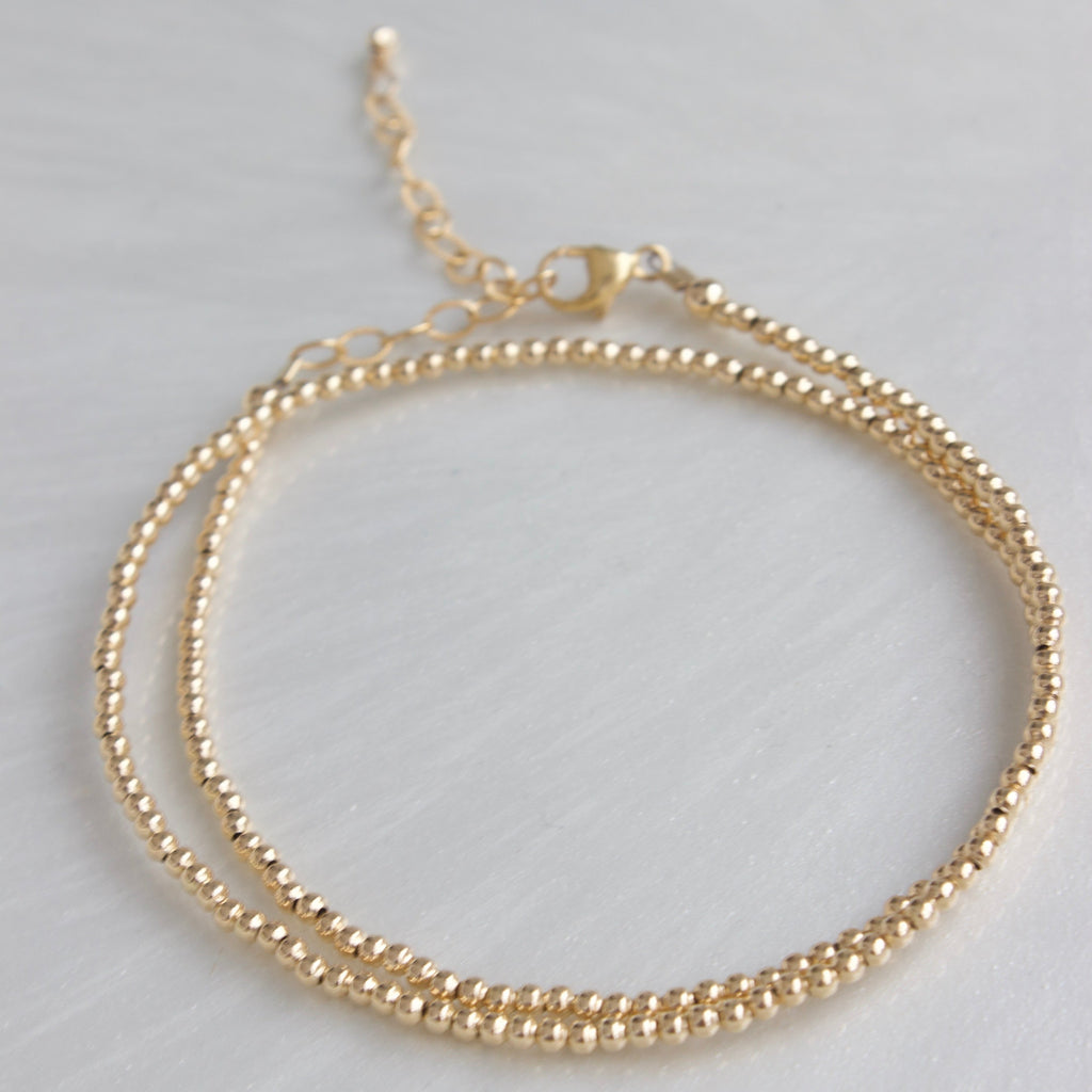 Our double wrap bracelet is one of our number one best selling bracelets! The petite double wrap beaded bracelet features a 2mm bead that can be worn as a bracelet or a single layer choker necklace!