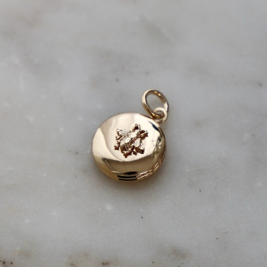 Add a buzz of personality to your jewelry collection with our Bee Locket Charm! This unique charm features a playful bee design and is perfect for storing tiny keepsakes. Make a statement with our Bee Locket Charm today!