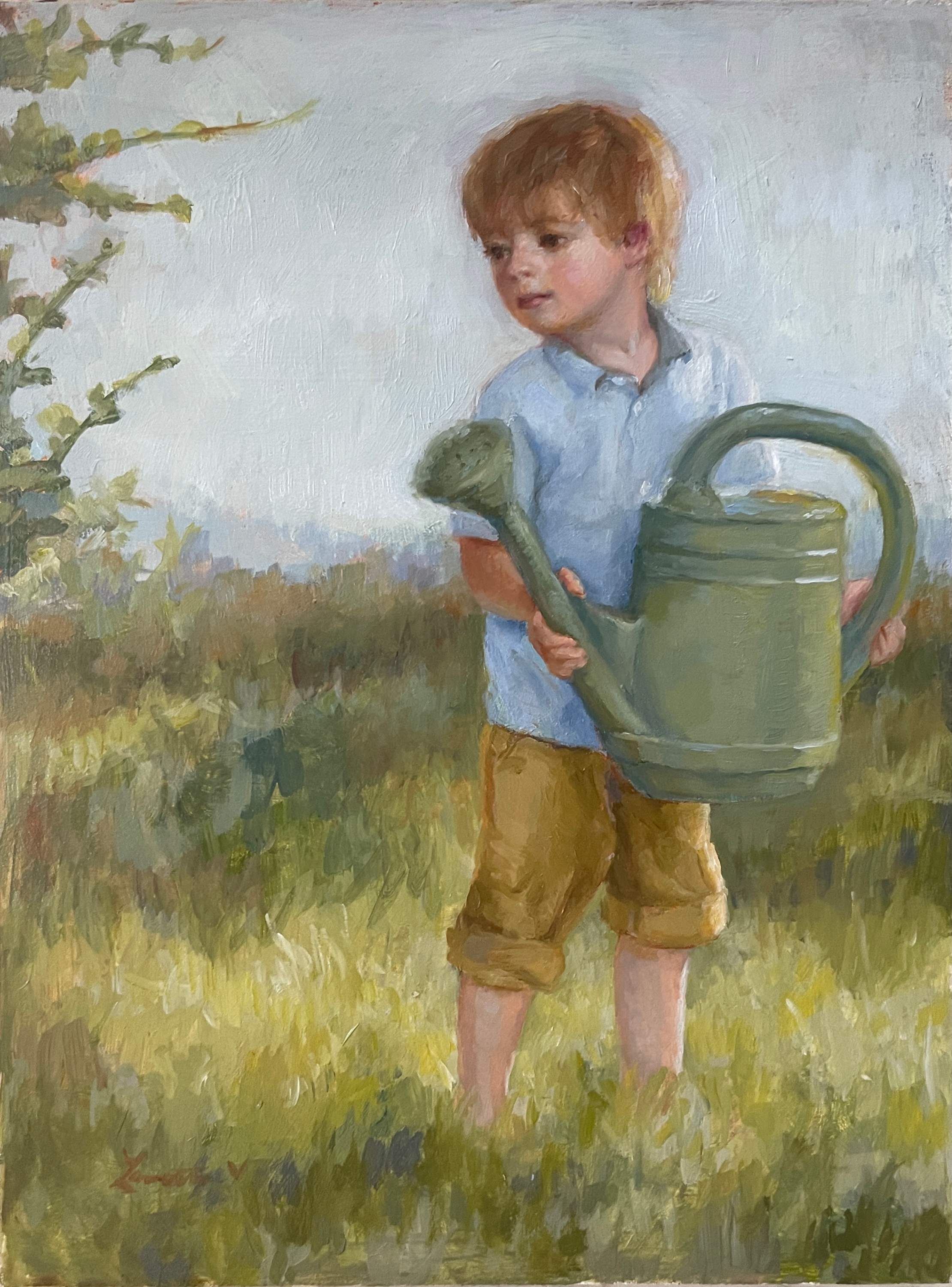 A little blonde boy, wearing a blue collared shirt and pants that are rolled up to his knees, holds a large green watering can. He is looking to the left as if he is about to water the shrub that is mostly out of frame, but some of it's branches are sticking into view. He is in a field of green and gold grass. 