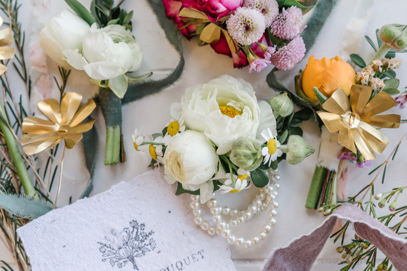 Collection of floral arrangements with a 'Taylor Rae Bouquet' card on a textured surface.