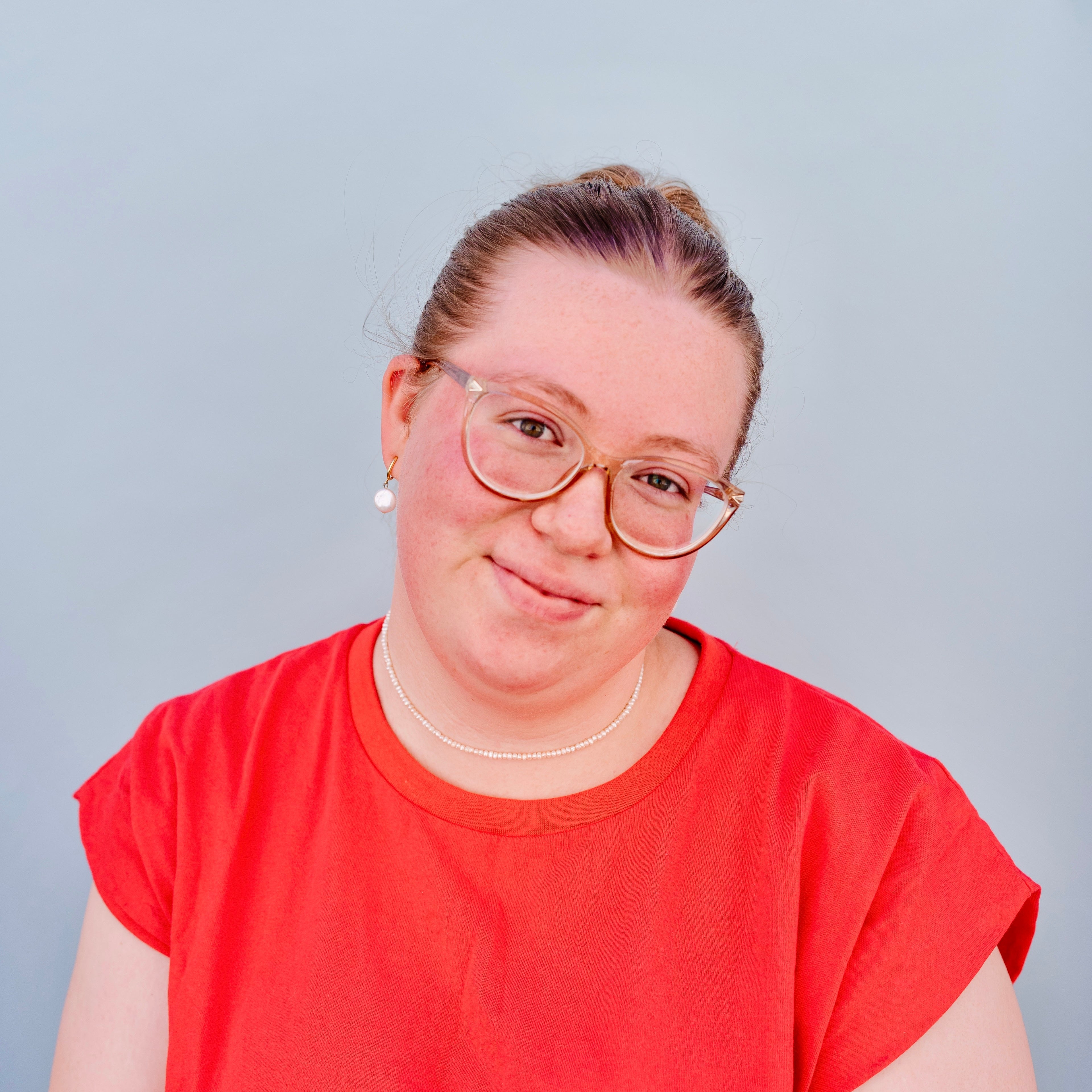 Person wearing a red shirt against a plain background