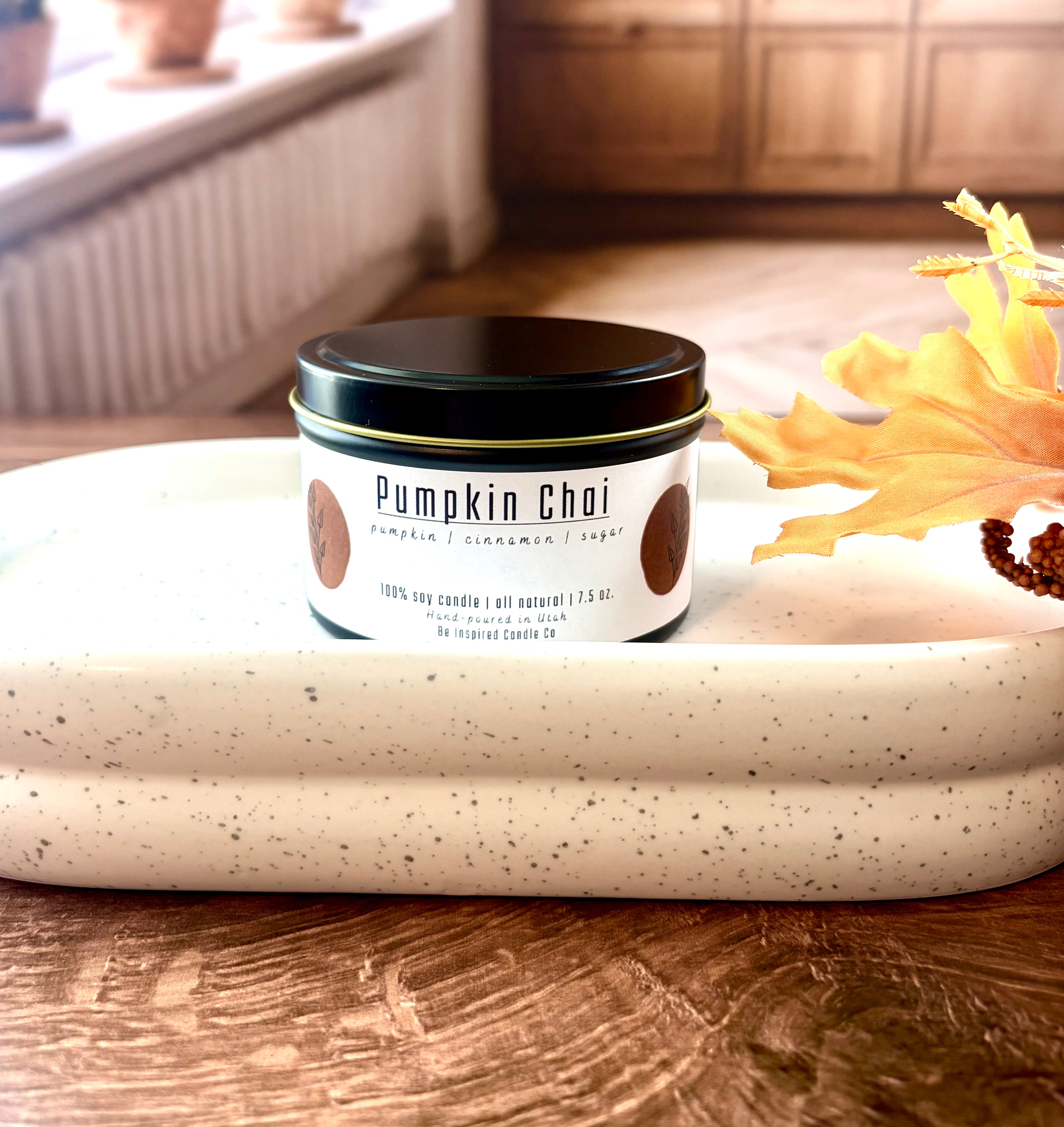 Medium black tin candle with a white label. 
