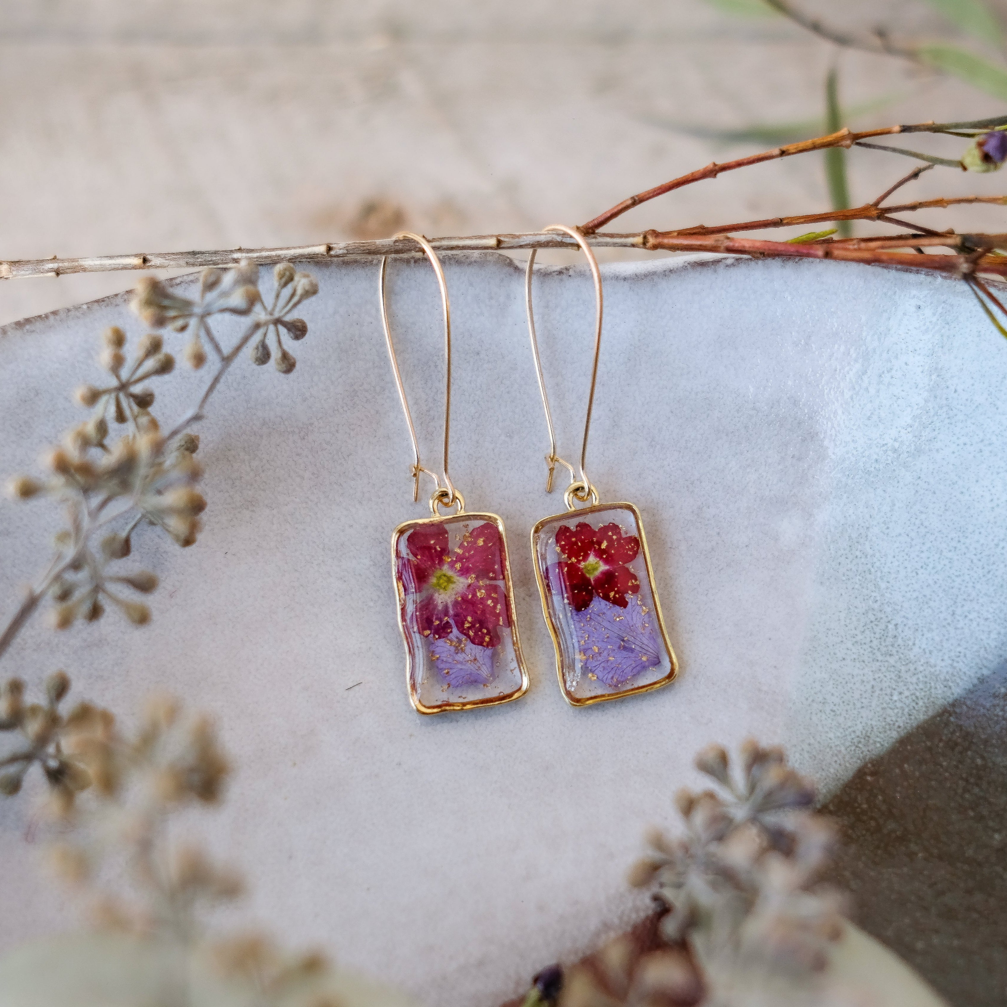 red and purple pressed flowers in gold rectangle bezels on hoops