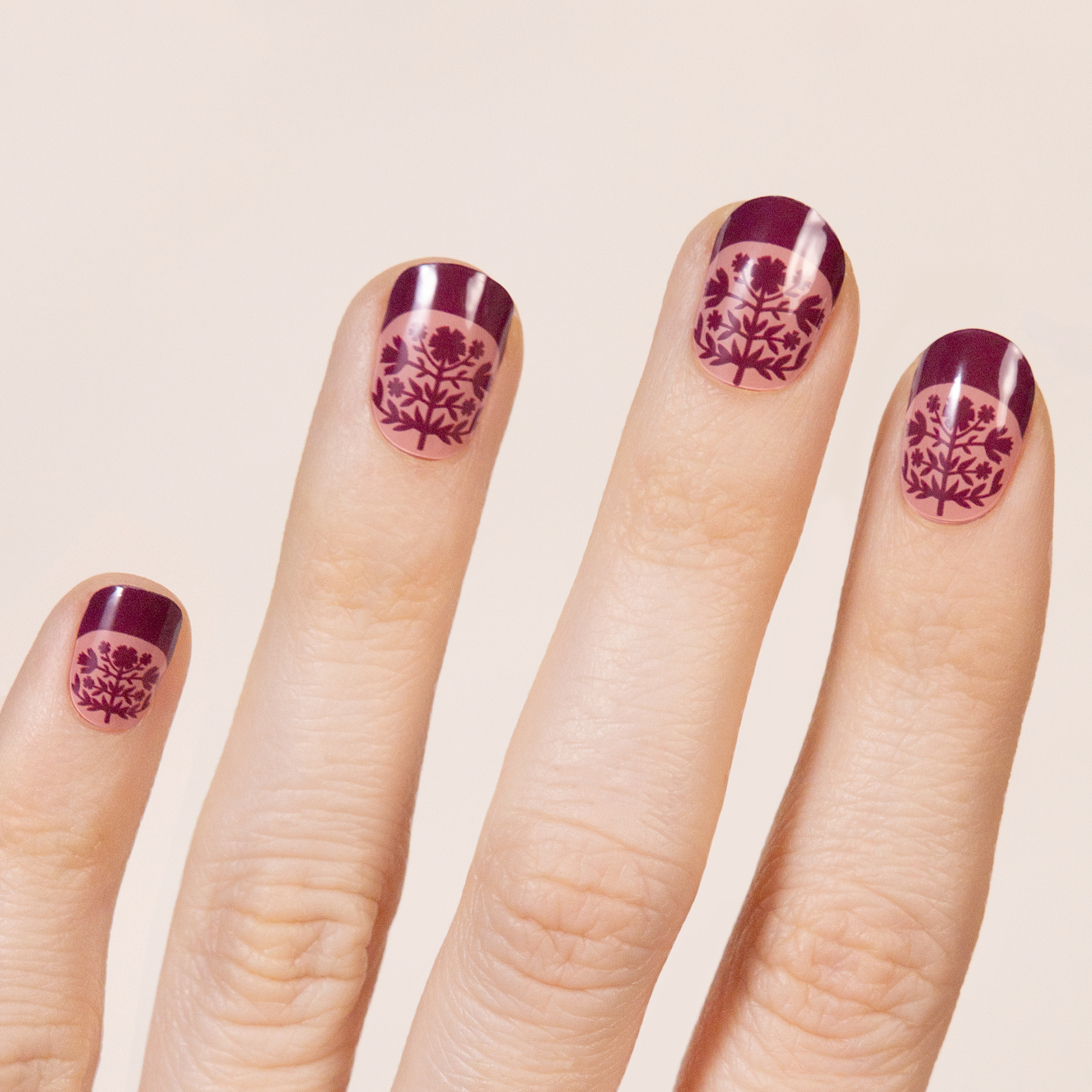 Symmetrical, Scandinavian inspired folk floral pattern in pink and maroon.