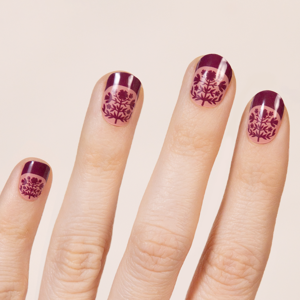 Symmetrical, Scandinavian inspired folk floral pattern in pink and maroon.