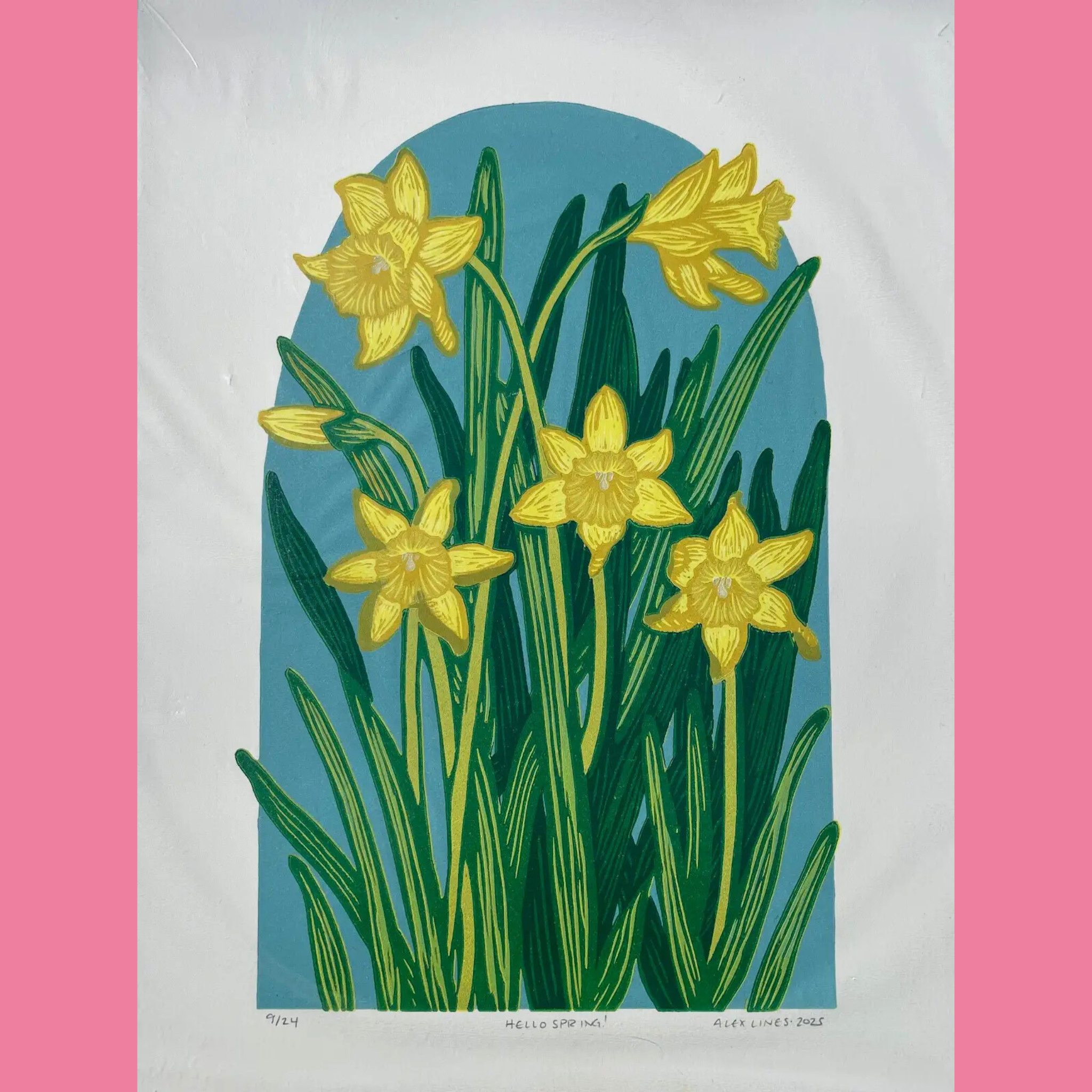 A vibrant linocut print depicts three cheerful yellow daffodil flowers with detailed petals and green stems and leaves, growing upward within a tall teal arched background that evokes a spring sky or window. The artwork is printed on white paper with the edition number "9/24," the title "HELLO SPRING!", and the signature "ALEX LINES • 2025" handwritten below, surrounded by a bright pink border.