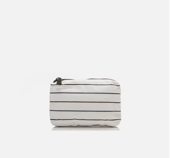Use this small pouch in white with black stripes as a wet bikini bag to keep your dry items separate after a swim, a surf session, or a day at the beach. This lightweight pouch will be your go-to makeup bag for travel or everyday use. It can also double as a cocktail-proof clutch to go from beach to bar or pool to pau hana.