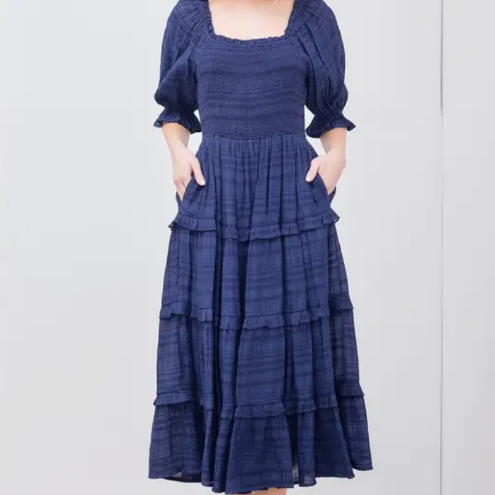Take your style up a notch with our Navy Tiered Midi Dress. This unique dress features playful layers and a delicate marrow hem detail. Perfect for a day out or a special event, this dress will surely turn heads and add a touch of whimsy to your wardrobe.