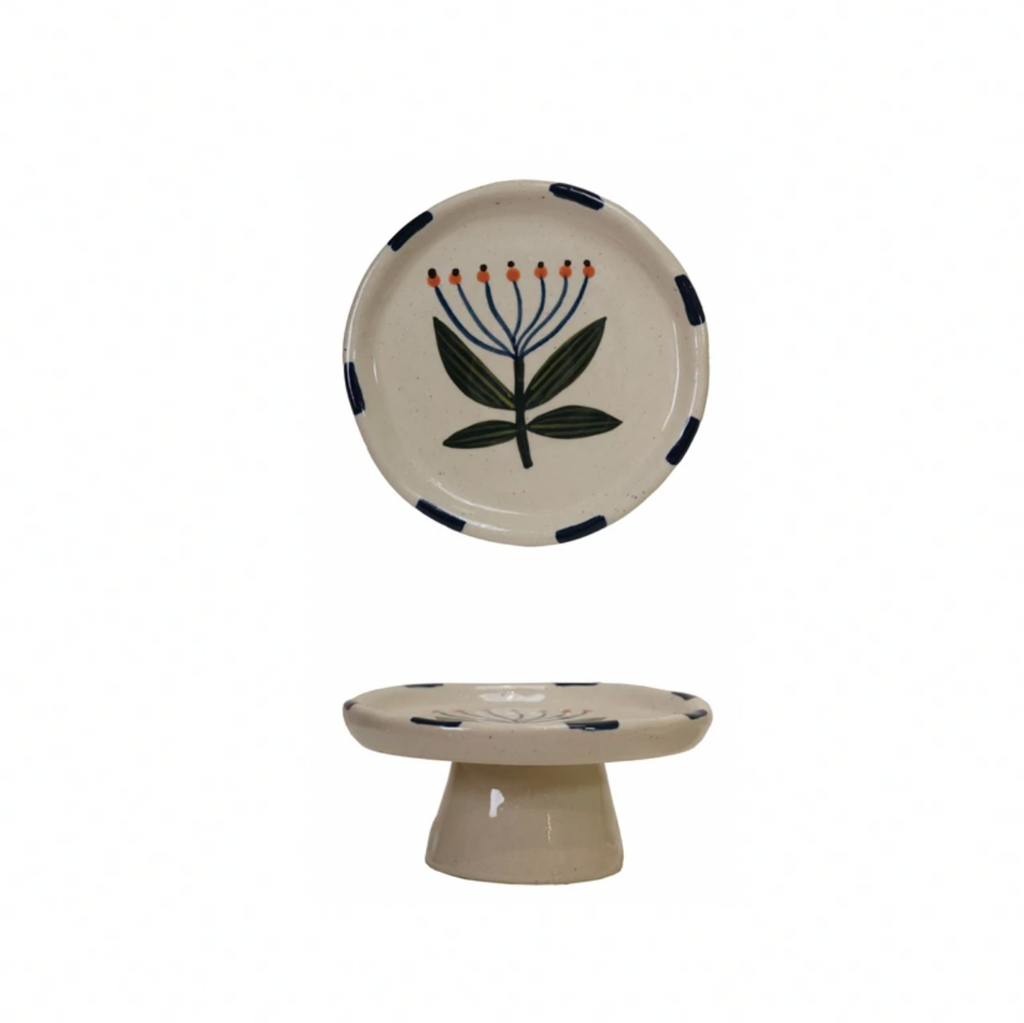 Add a splash of charm to your table with this Hand-Painted Stoneware Pedestal featuring a delightful blue flower design. Perfect for showcasing desserts or elevating your favorite treats, its sturdy stoneware build combines beauty and function. Brighten up any gathering with this playful centerpiece that’s as practical as it is pretty! 5" Round x 2-1/2"H