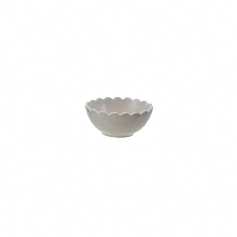 Small white ceramic bowl with scalloped edge on a white background