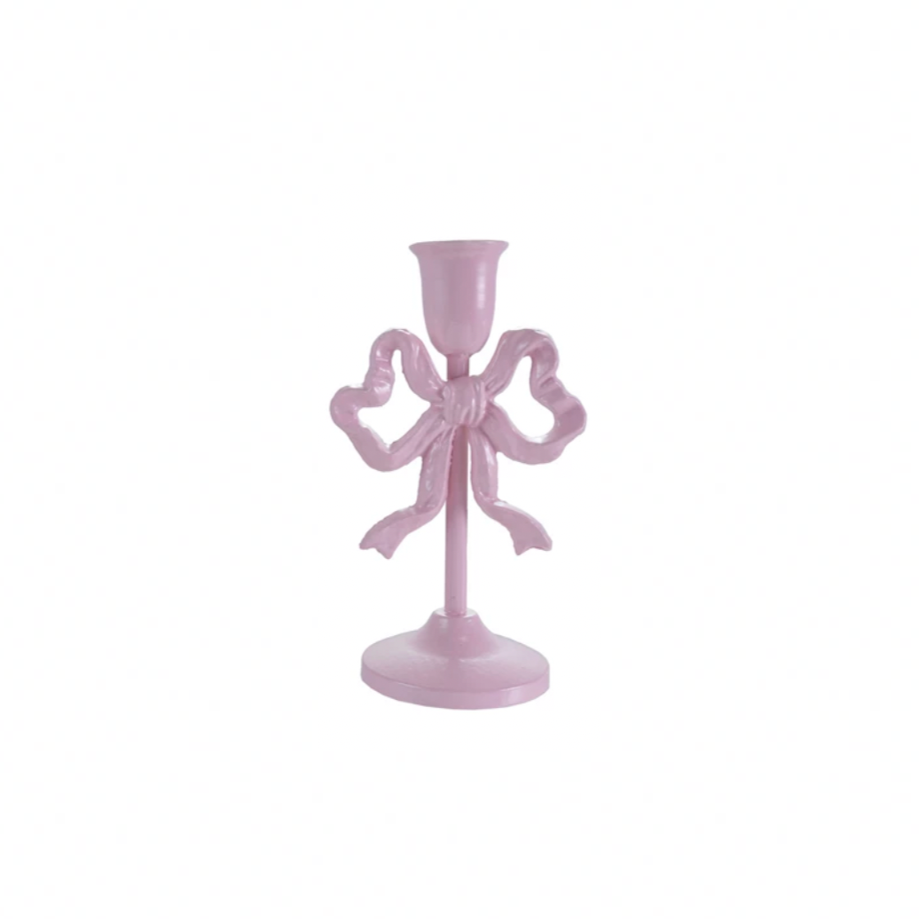 Pink candle holder with bow design on a white background
