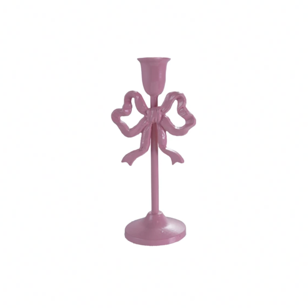 Pink candle holder with bow design on a white background
