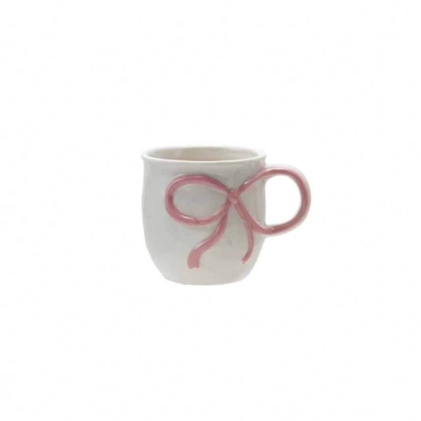 White mug with a pink bow design on a white background