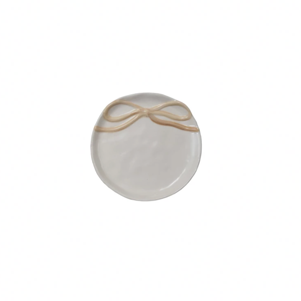 Round ceramic plate with a gold bow design on a white background