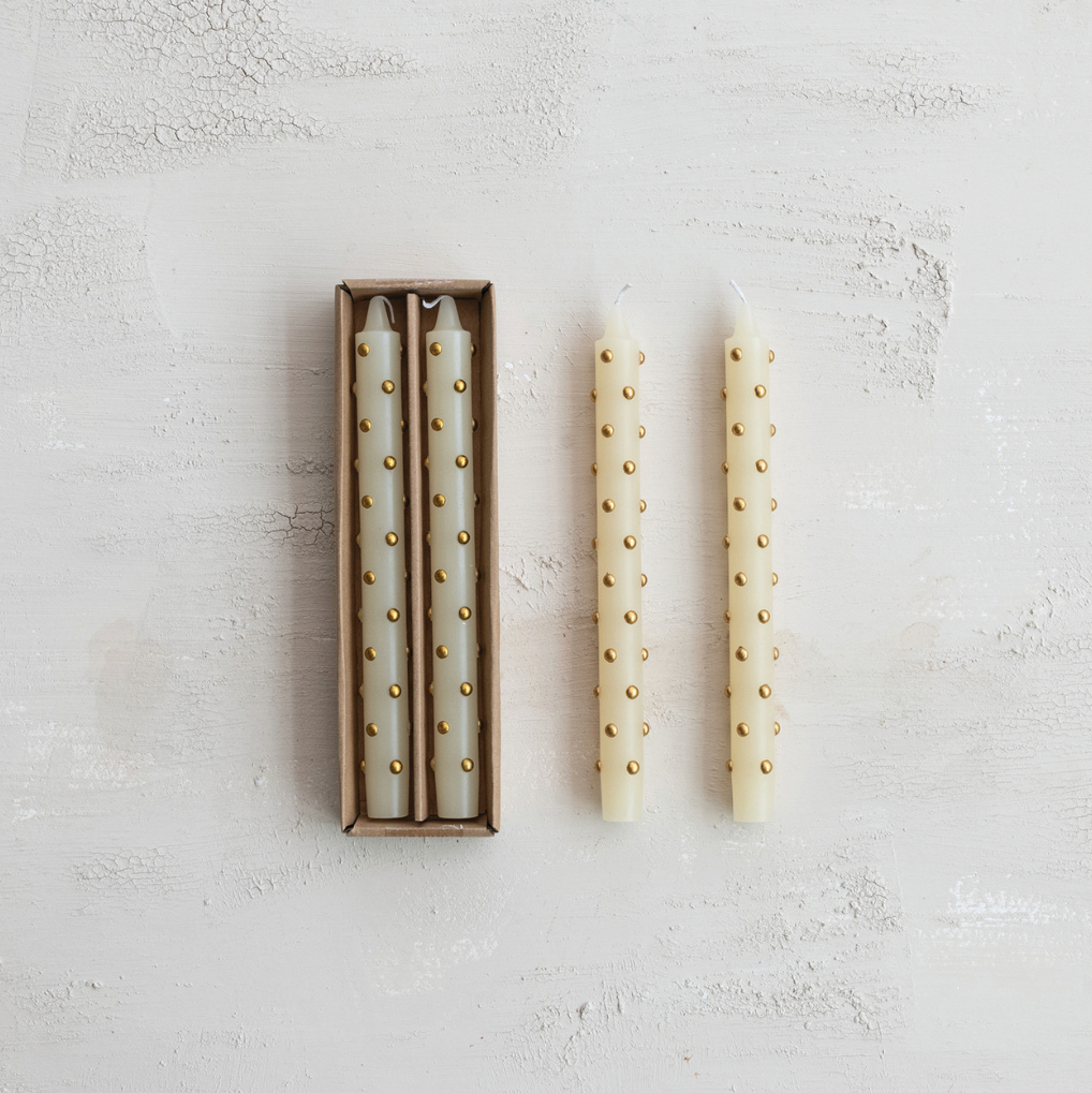 Two decorative candles with pearl-like beads on a light gray surface.