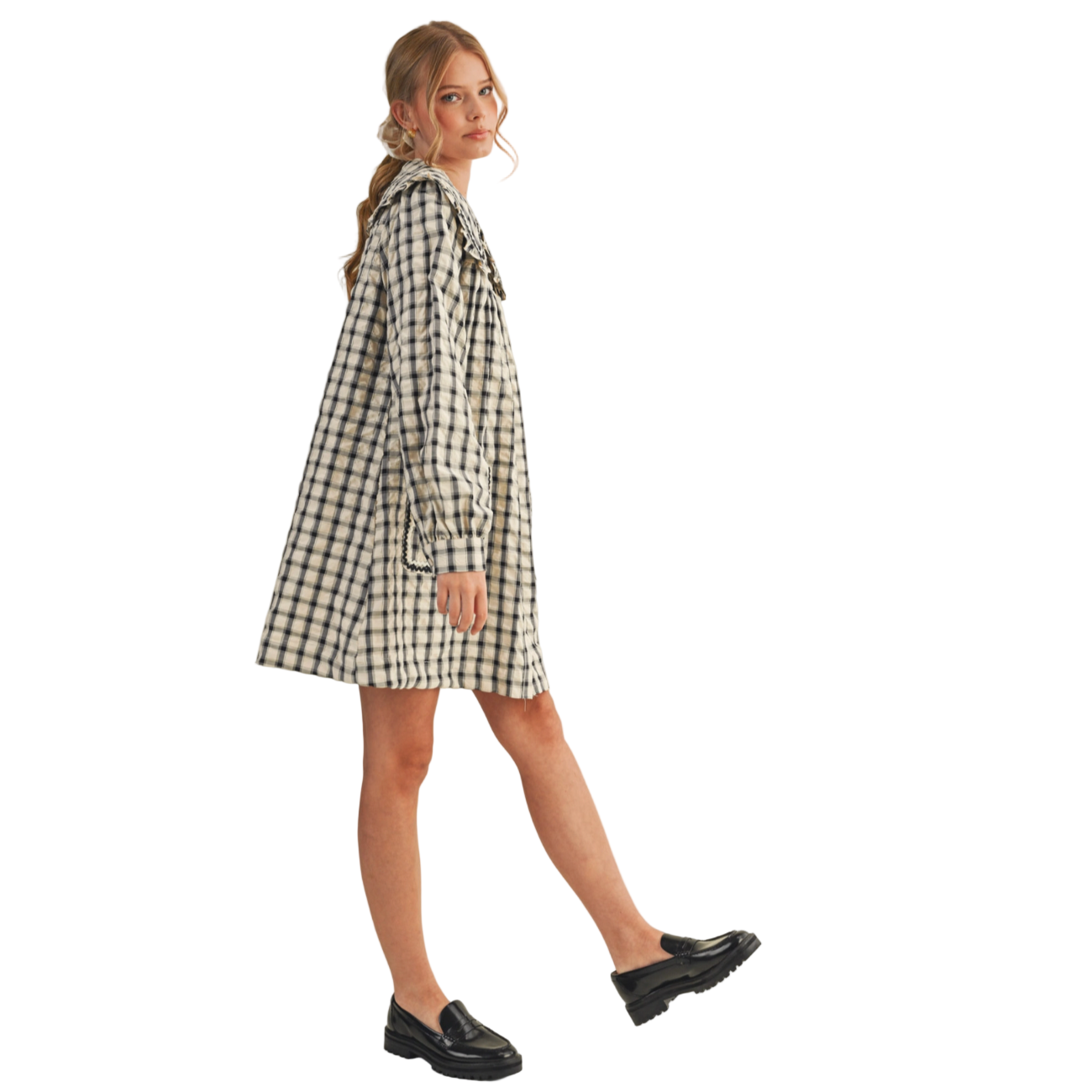 Woman wearing a black and white checkered dress on a beige background