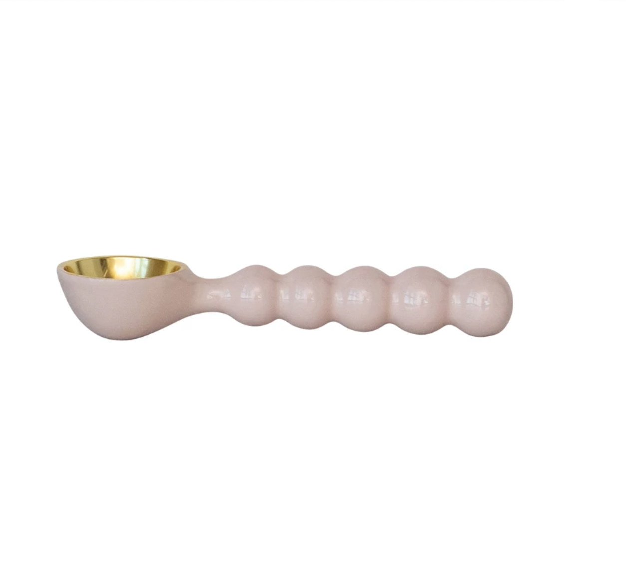 Pink ceramic spoon with gold interior on a white background