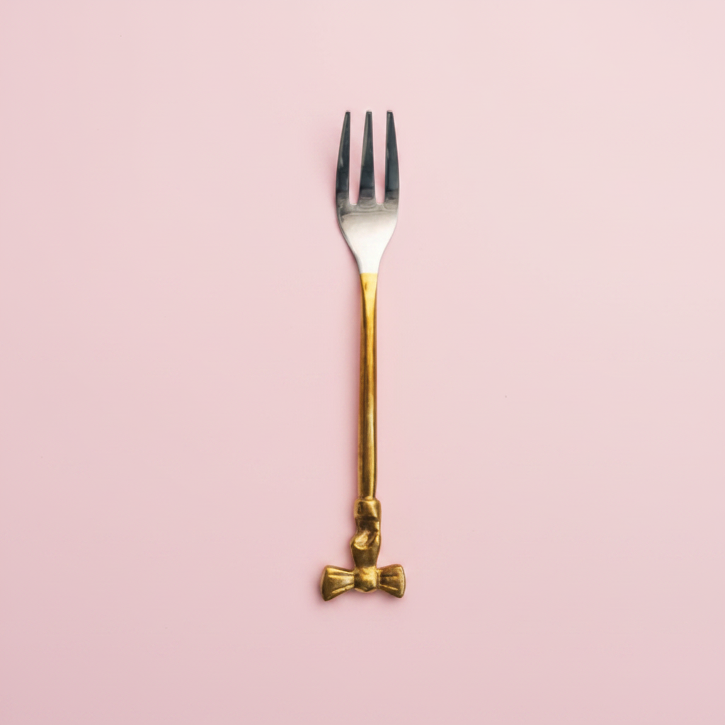 Gold fork with a bow design on HANDLE ON a white background