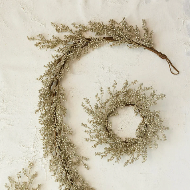 Two decorative wreaths made of small branches on a textured white background