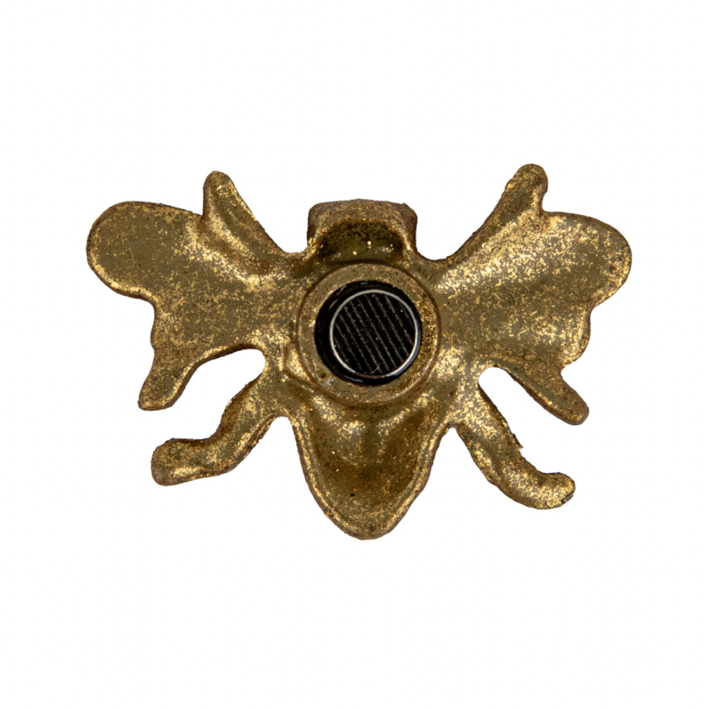 Gold bee-shaped magnet on a white background
