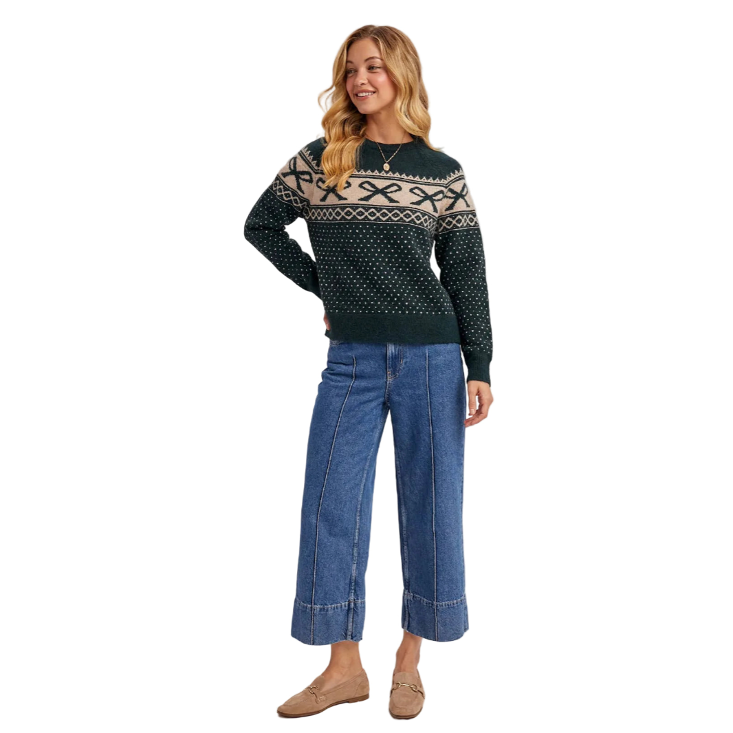 Woman wearing a patterned sweater and jeans on a white background