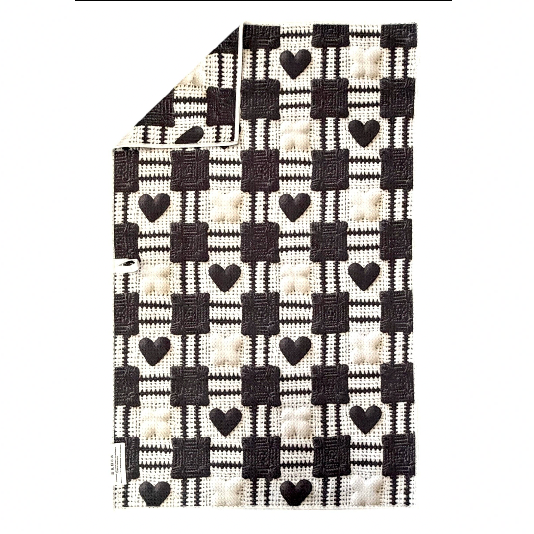 Black and white checkered fabric with heart patterns on a white background
