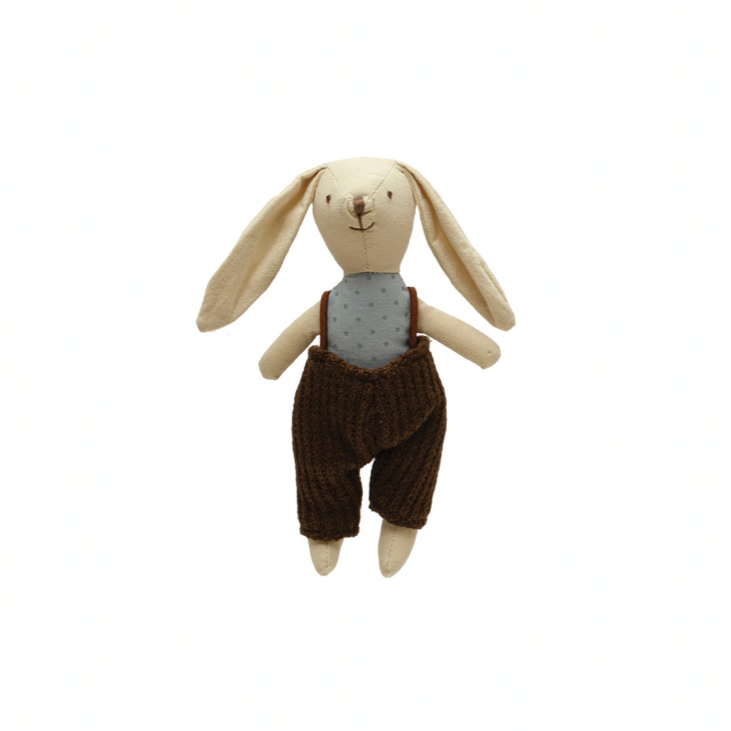 Stuffed toy rabbit with tank top and overalls on a white background