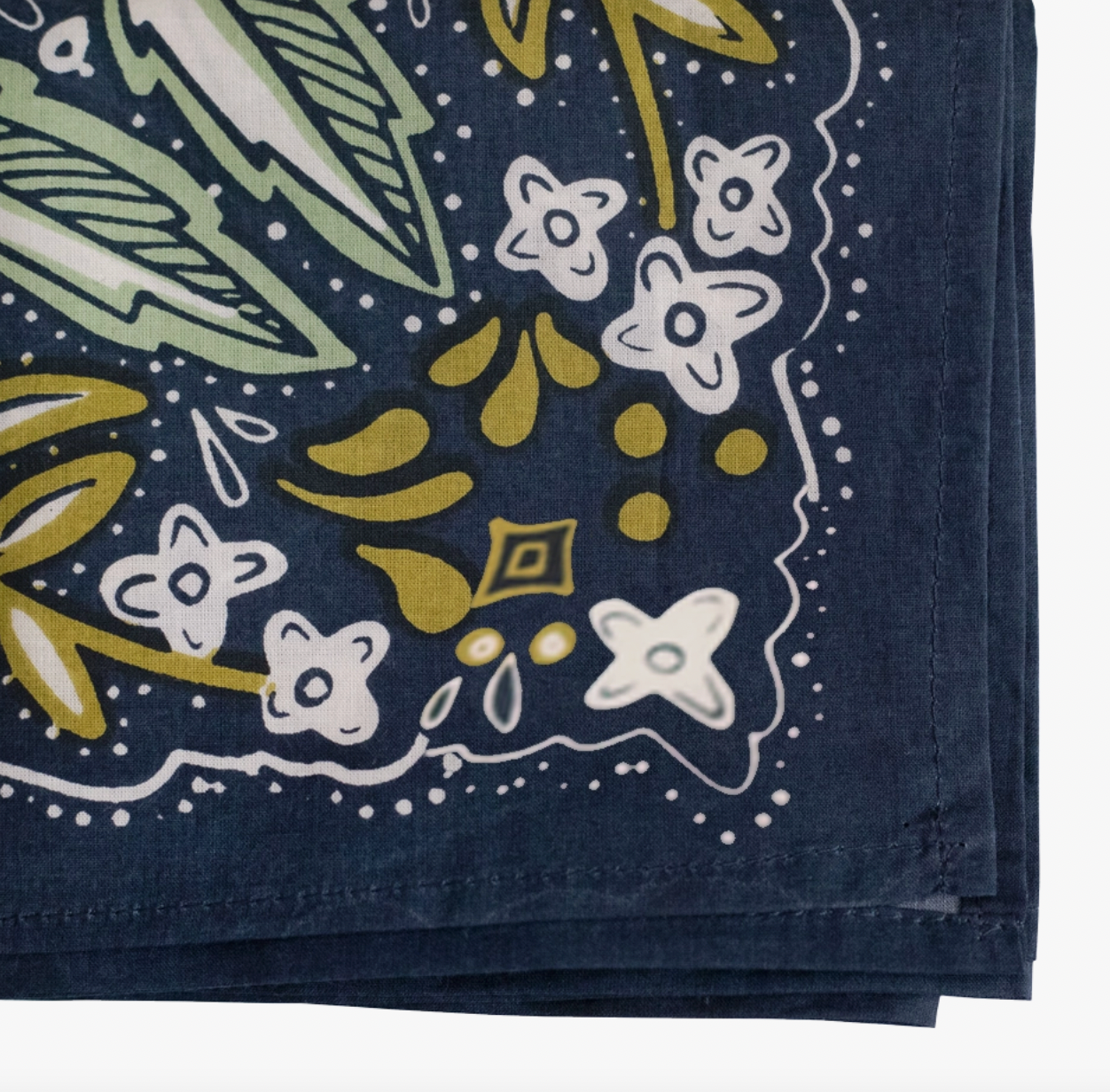 A folded navy blue bandana or scarf featuring a hand-drawn style botanical pattern in white, olive green, and mustard yellow on a white background.