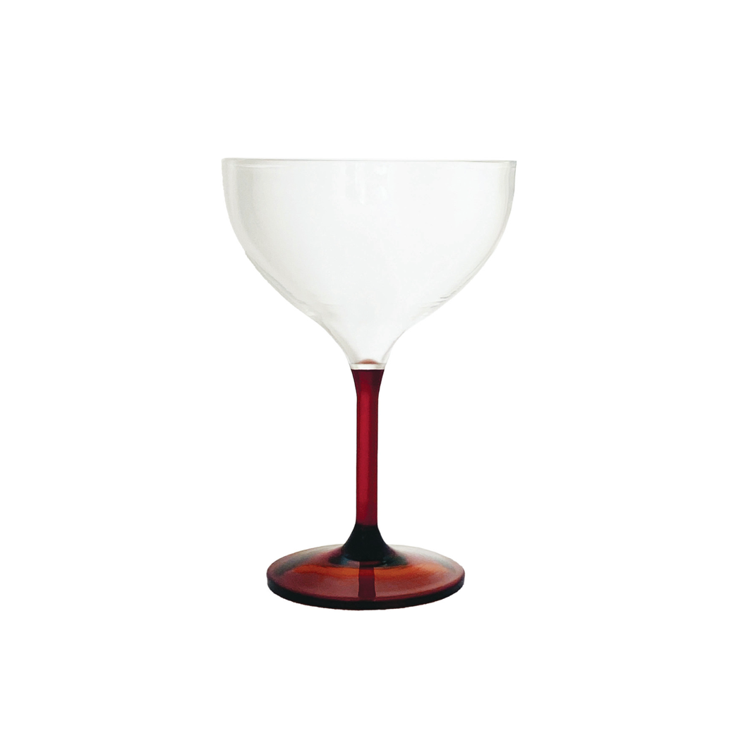 A coupe glass with a clear frosted bowl and a dark red translucent stem and base, isolated on a white background.
