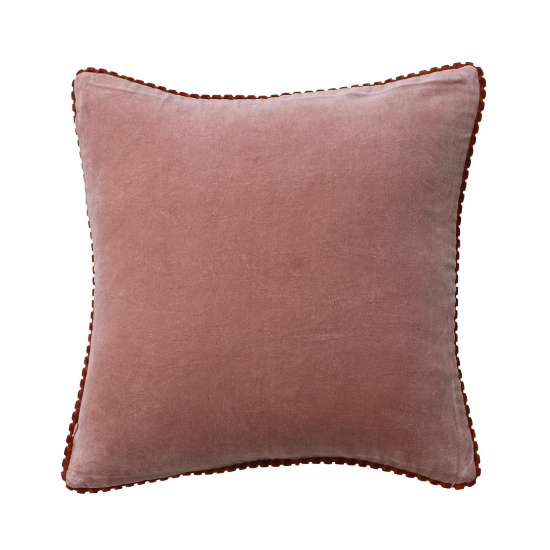 A square dusty rose velvet throw pillow with scalloped brown trim, shown against a plain white background.