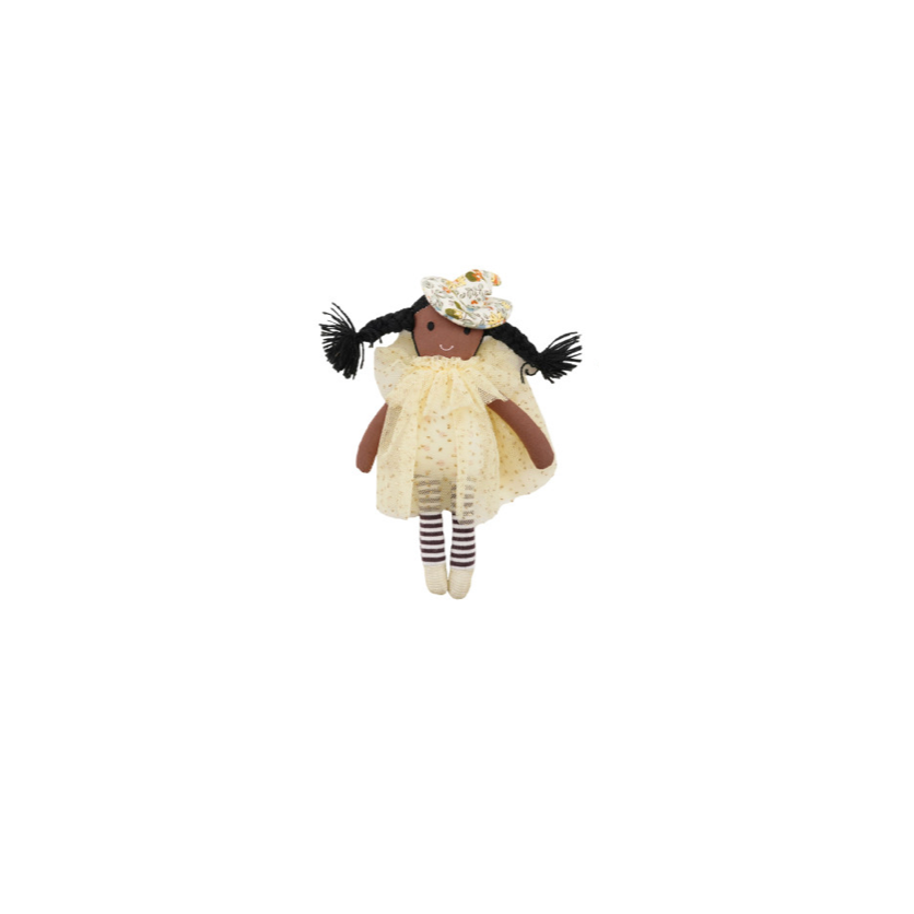 A small handmade witch doll with black pigtails, a cream dress, striped socks, and a floral headband, centered on a solid white background.