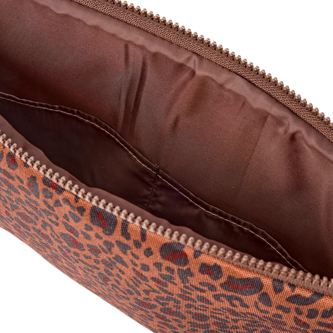 Close-up of a leopard-print zippered pouch showing the brown interior lining and zipper details against a white background.