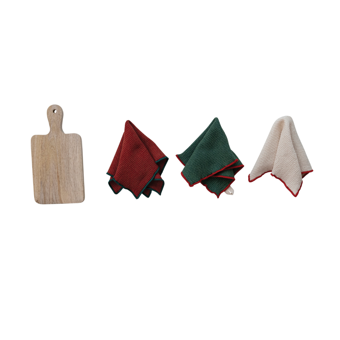 Four kitchen accessories arranged horizontally on a white background: a light wood cutting board with a handle hole, a folded red cloth napkin with dark green edges, a folded dark green cloth napkin with red edges, and a folded off-white cloth napkin with red edges.