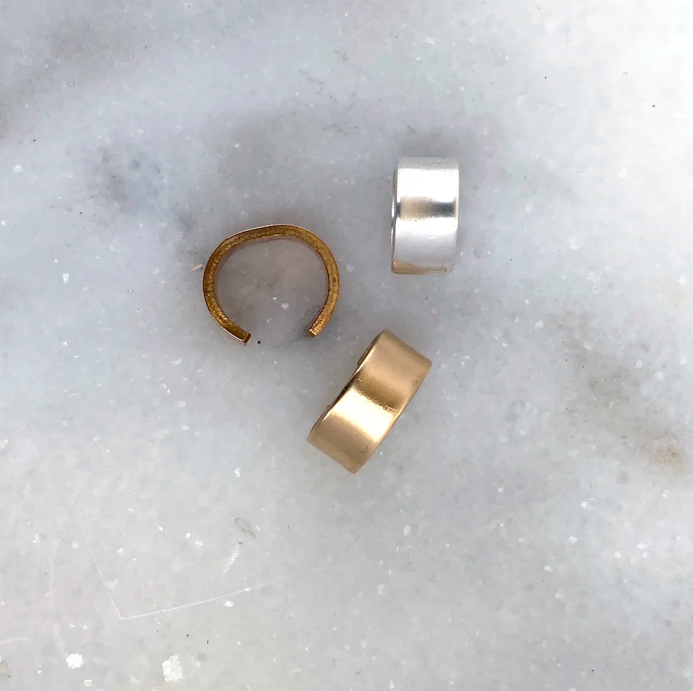 A lightweight, 3/8" band of metal that gently wraps as an adjustable cuff. 