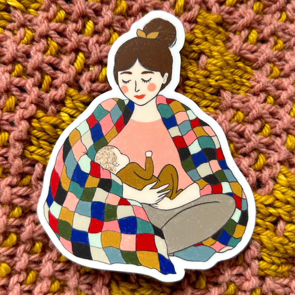 Mother with brown hair and fair skin wearing a pink top holding a fair skinned infant wearing a mustard onesie. 