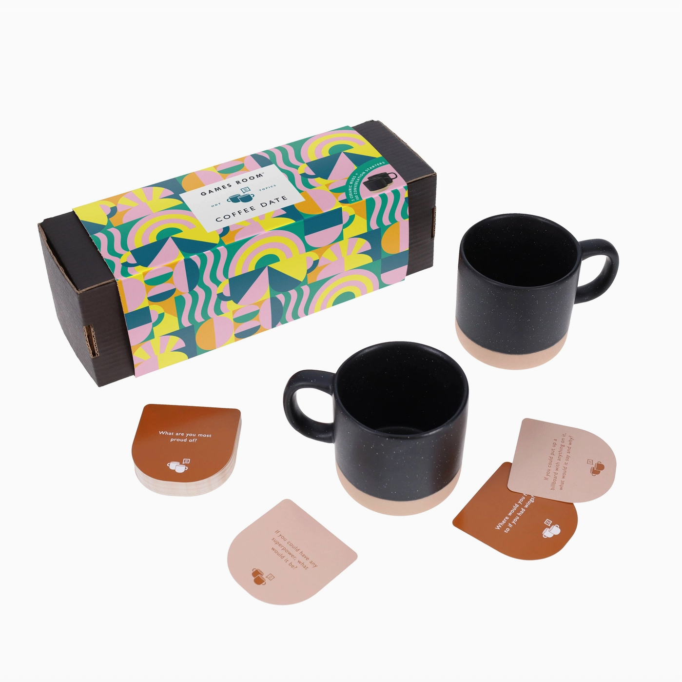 Coffee Date box, a few example cards strewn about, and two coffee mugs, showing the contents of the box. 
