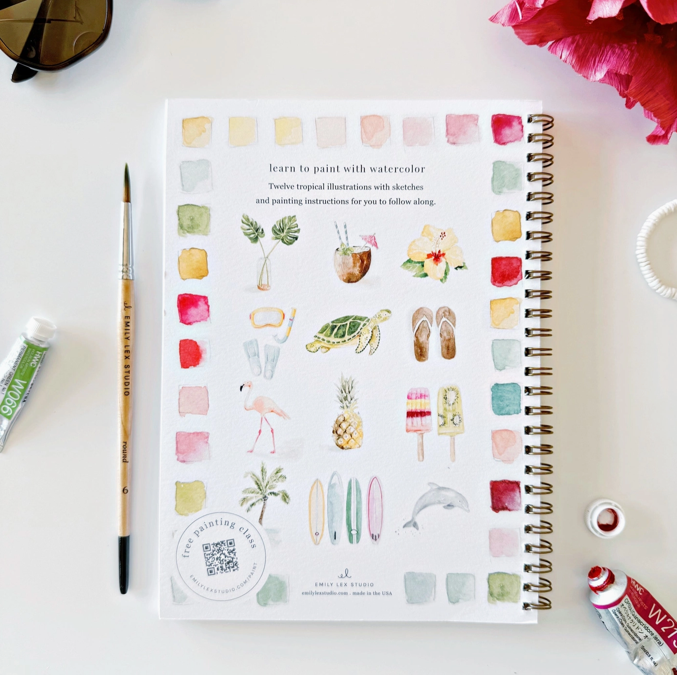The back of the Tropical watercolor book, with scenes of a sea turtle, palm leaves, scuba gear, a flamingo, popsicles, a dolphin, surfboards, palm trees, a coconut, flip flops, etc. 