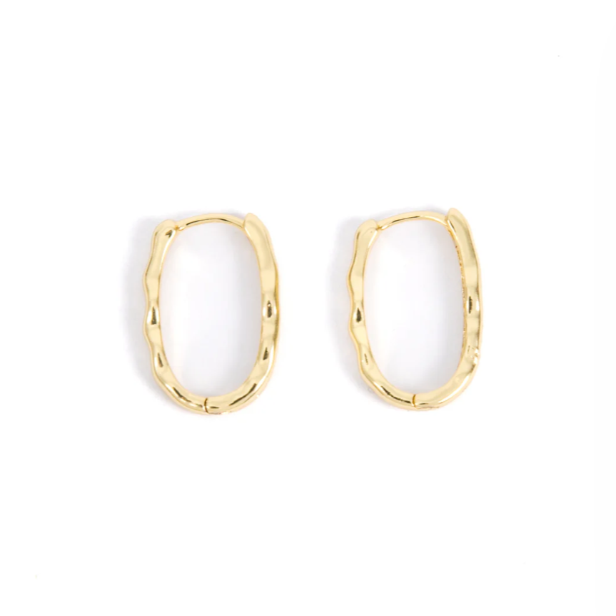 A pair of gold oval hoop earrings with a softly wavy edge are shown against a white background.