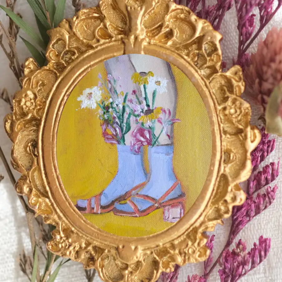 A pair of feet and calves wearing mid calf socks with wildflowers sticking out of the socks. 