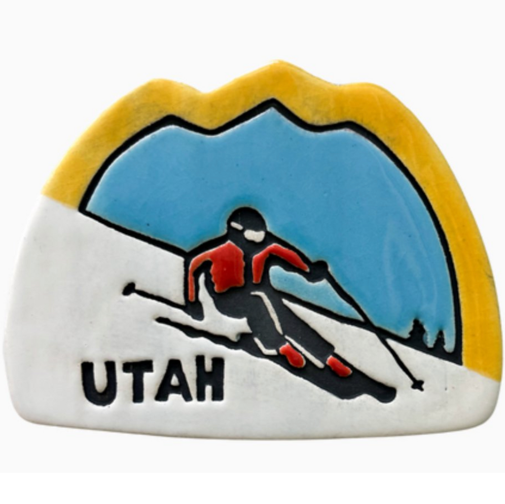 Ceramic ornament featuring a downhill skier on the slopes. 