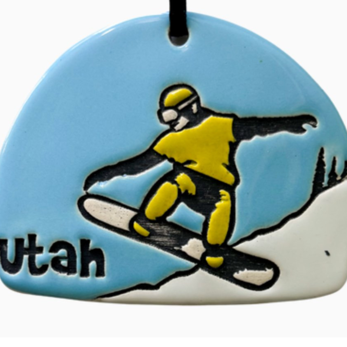 Ceramic ornament featuring a snowboarder pulling an ollie down the slope. 